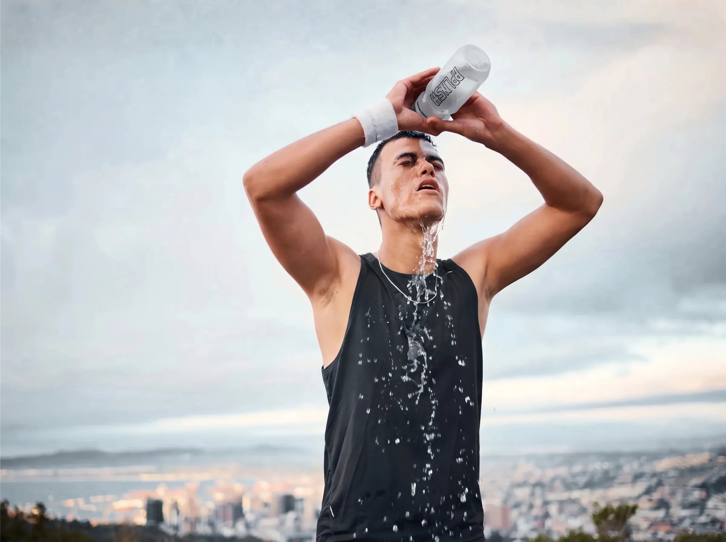 An athlete pouring water over their head after training
